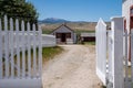 Deer Lodge, Montana - June 30, 2021: White picket fence gate leads to more historic buildings at Grant-Kohrs National Historic Royalty Free Stock Photo