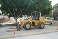 A Deere bulldozer in the middle of the street.