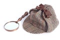 Deerstalker or Sherlock Holmes cap and vintage magnifying glass Royalty Free Stock Photo