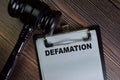 Defamation write on a paperwork isolated on Wooden Table