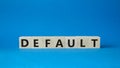 Default symbol. Concept word Default on wooden cubes. Beautiful blue background. Business and Default concept. Copy space