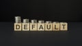 DEFAULT word concept on wooden blocks on a black table with coins