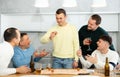 Defeated man taking shot while playing drinking board game with friends