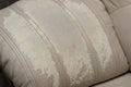 Defects on a white leather sofa. Damaged to leather furniture.