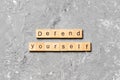 Defend yourself word written on wood block. defend yourself text on cement table for your desing, concept