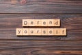 Defend yourself word written on wood block. defend yourself text on cement table for your desing, concept