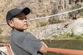 Defiant kid with cup looking at the camera with river and mountains Royalty Free Stock Photo