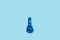 A deflated blue balloon on a blue background