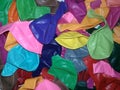 Deflated colorful balloons lie in a heap