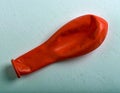 Deflated red balloon on a textured surface symbolizing disappointment and letdown Royalty Free Stock Photo