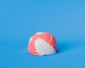 Deflated Red and White Beach Ball on Blue Background Royalty Free Stock Photo