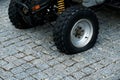 Deflated tire of 4x4 quad bike on a pavement. Off road vehicle with flat tire after a dangerous ride in nature. Popular