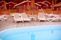 Defocus Autumn landscape recreation deck chairs pool umbrella wooden house fence.