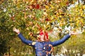 Defocus autumn people. Teen girl raising hand and throwing leaves. Many flying orange, yellow, green dry leaves. Enjoy Royalty Free Stock Photo