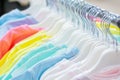 Defocus background wallpaper backdrop bokeh, summer clothes hanging on hangers in a store. cotton natural t-shirts white pink Royalty Free Stock Photo