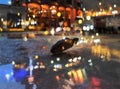 Defocus black umbrella evening rainy street blurred night light reflection on house vitrines on wet pavement Autumn medieval