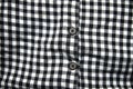 Defocus black and white shirt. Gingham tablecloth back pattern. Fragment of a wrinkled squared black and white shirt