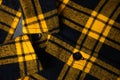 Defocus black and yellow checkered shirt. Gingham tablecloth back pattern. Fragment of a wrinkled squared black and