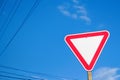 Defocus blank empty triangle red warning road sign with blue sky background. Danger direction. Out of focus Royalty Free Stock Photo