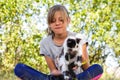 Defocus blonde little girl holding and caress cat, black and white small beautiful kitten. Nature green summer Royalty Free Stock Photo