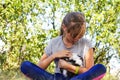 Defocus blonde little girl holding and caress cat, black and white small beautiful kitten. Nature green summer