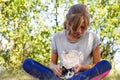 Defocus blonde little girl holding and caress cat, black and white small crazy kitten. Nature green summer background