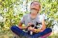 Defocus blonde little girl holding and caress cat, black and white small kitten. Nature green summer background. Girl holding and Royalty Free Stock Photo