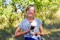 Defocus blonde little smiling girl holding and caress cat, black and white small cute kitten. Nature green summer Royalty Free Stock Photo