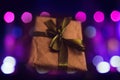 Defocus craft eco gift box with magical light against blurred bokeh light background. Purple bokeh. Out of focus Royalty Free Stock Photo