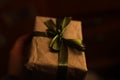 Defocus craft eco gift box with magical light against dark light background. Dark night. Hand holding present. Out of Royalty Free Stock Photo