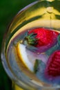 Defocus cropped close-up glass jug of lemonade with strawberry, slice lemon and leaves of mint on yellow board. Blurred Royalty Free Stock Photo