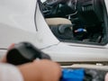 Defocus foreground of woman`s hands holding and using mini air pump, connected to the car plug, to inflate a balloon Royalty Free Stock Photo