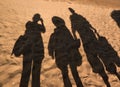 Defocus funny silhouettes of a family of three people on grains of beach sand