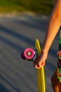 Defocus girl holding yellow penny board. Back view. Youth hipster culture. Close-up child hands holding short cruiser Royalty Free Stock Photo