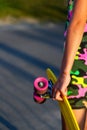 Defocus girl holding yellow penny board. Back view. Youth hipster culture. Close-up child hands holding short cruiser Royalty Free Stock Photo
