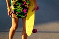 Defocus girl holding yellow penny board. Front view. Youth hipster culture. Child hands holding short cruiser pennyboard