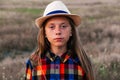 Defocus girl kid in hat looking at camera. Portrait of sad little girl at the day time. Meadow nature background. Out of Royalty Free Stock Photo