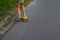 Defocus girl playing on yellow skateboard in the street and roadside. Caucasian kid riding penny board, practicing