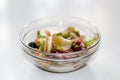 Defocus glass bowl with salad on white background. Different leaves of various leafy vegetables, chard, spinach, arugula