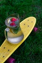 Defocus glass jug of lemonade with strawberry, slice lemon and leaves of mint on yellow penny board, skateboard. Blurred Royalty Free Stock Photo
