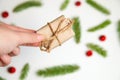 Defocus hand holding eco gift. White fir background. Woman hands opening gift box. Christmas, new year, birthday concept