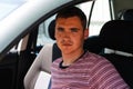 Defocus happy smiling caucasian young man sitting in car. 20s guy looking from open window. Silver grey gray car