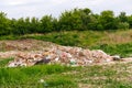 Defocus huge ruins , wreck in Ukraine, war. Concept of ecology. Large garbage pile on nature green grass background Royalty Free Stock Photo