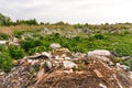 Defocus huge ruins, wreck in Ukraine, war. House after russian attack. Large garbage pile on nature green grass Royalty Free Stock Photo