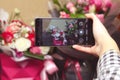 Defocus male hand taking photo of colorful roses with cell, mobile phone. Woman with a gift of flowers. Female florist Royalty Free Stock Photo