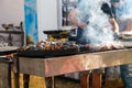 Defocus Man Cooking Bbq Meat At Festival Outdoor. Seafood Paella. Chef Grilling Sausages In Park Outside. Concept Of