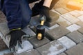 Defocus paver master. Man lays paving stones in layers. Garden brick pathway paving by professional paver worker. Hands Royalty Free Stock Photo