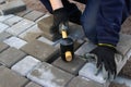 Defocus paver master. Man lays paving stones in layers. Garden brick pathway paving by professional paver worker. Hands Royalty Free Stock Photo