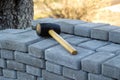 Defocus paving hammer. Stack of paving stones. Garden brick pathway paving by professional paver worker. Laying gray