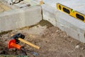 Defocus Paving stone blocks on sand. Yellow spirit level, hammer, mallet, chisel lie on the ground. Set of tools for laying paving